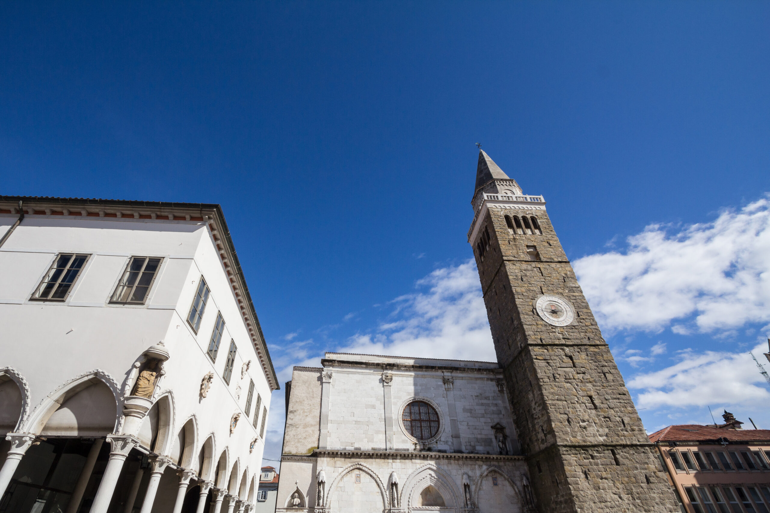 Picture of the tito square in Koper, Slovenia, with the cathedral of the assumption and the praetorian palace. The Cathedral of the Assumption of the Blessed Virgin Mary, or stolna cerkev Marijinega vnebovzetja also called Koper Cathedral is the Catholic cathedral of the Diocese of Koper, in the city of Koper, Slovenia. The Praetorian Palace  is a 15th-century Venetian Gothic palace in the city of Koper, in southwest Slovenia. Located on the southern side of the city's central Tito Square, it houses the Koper city government and a wedding hall. It is considered one of the city's architectural landmarks.